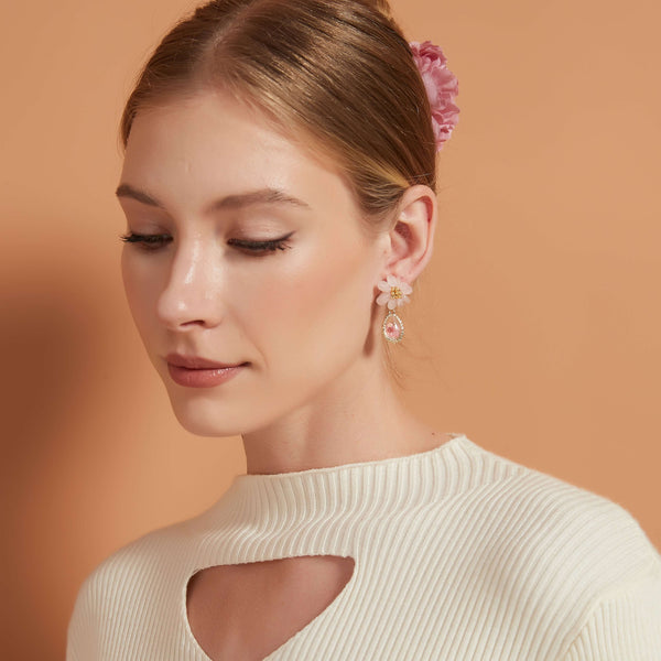 Discover the enchanting beauty of our Pink Quartz Pink Floral Resin Drop, featuring a real flower delicately captured in a golden frame and encased in clear resin. This unique accessory combines the natural allure of preserved blooms with the elegance of pink quartz, creating a timeless piece. Perfect for adding a touch of nature-inspired sophistication to any outfit.